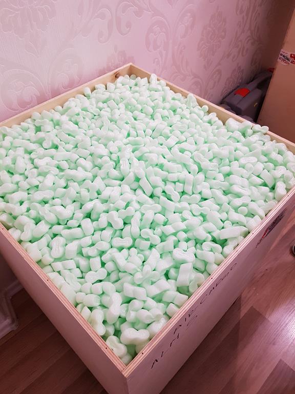 Drewniana skrzynia wypełniona granulatem pakowym