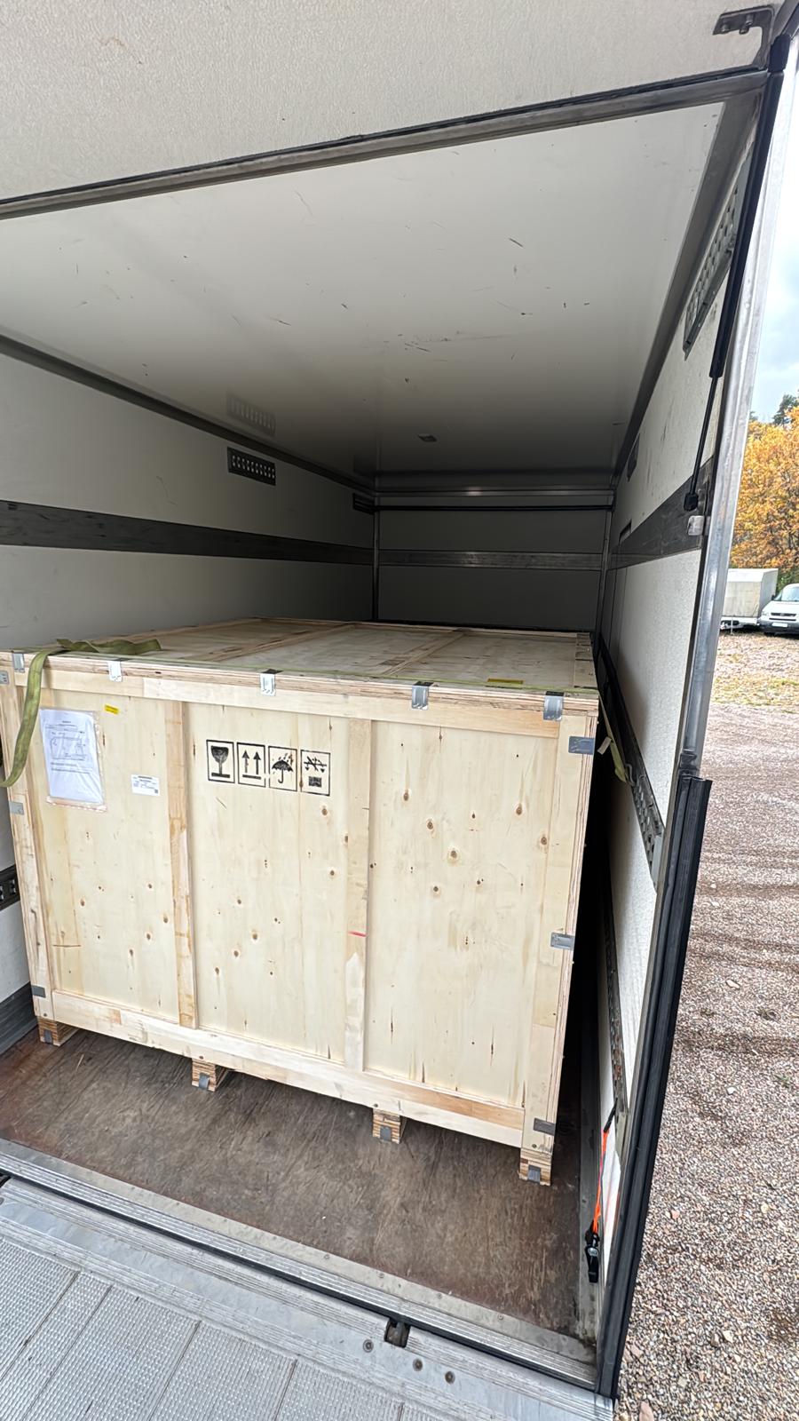 Drewniana skrzynia transportowa załadowana do samochodu Najtrans